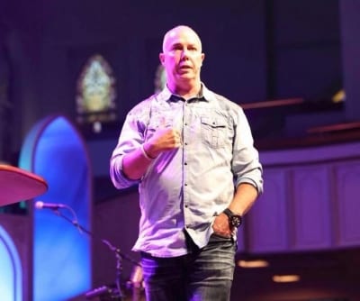 Gene in front of an audience speaking